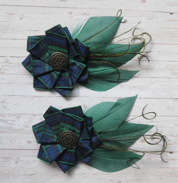 Two green floral hair accessories on a wooden surface