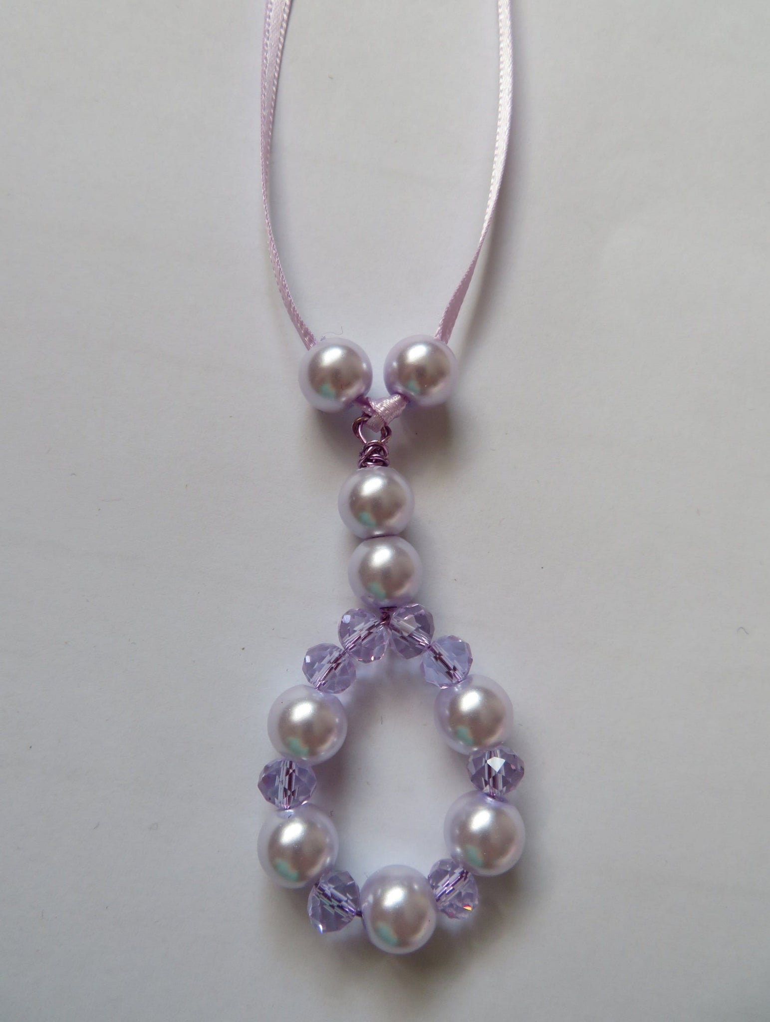 Pearl and purple bead necklace on a white background