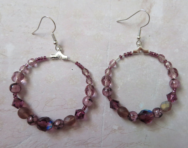 Pair of beaded hoop earrings on a textured surface