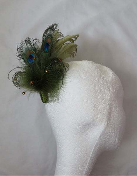 Peacock feather hair clip on a white background