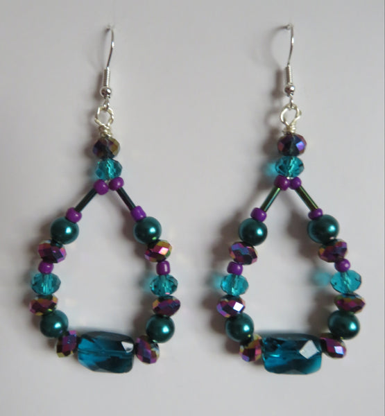 Pair of beaded earrings with blue and purple beads on a white background