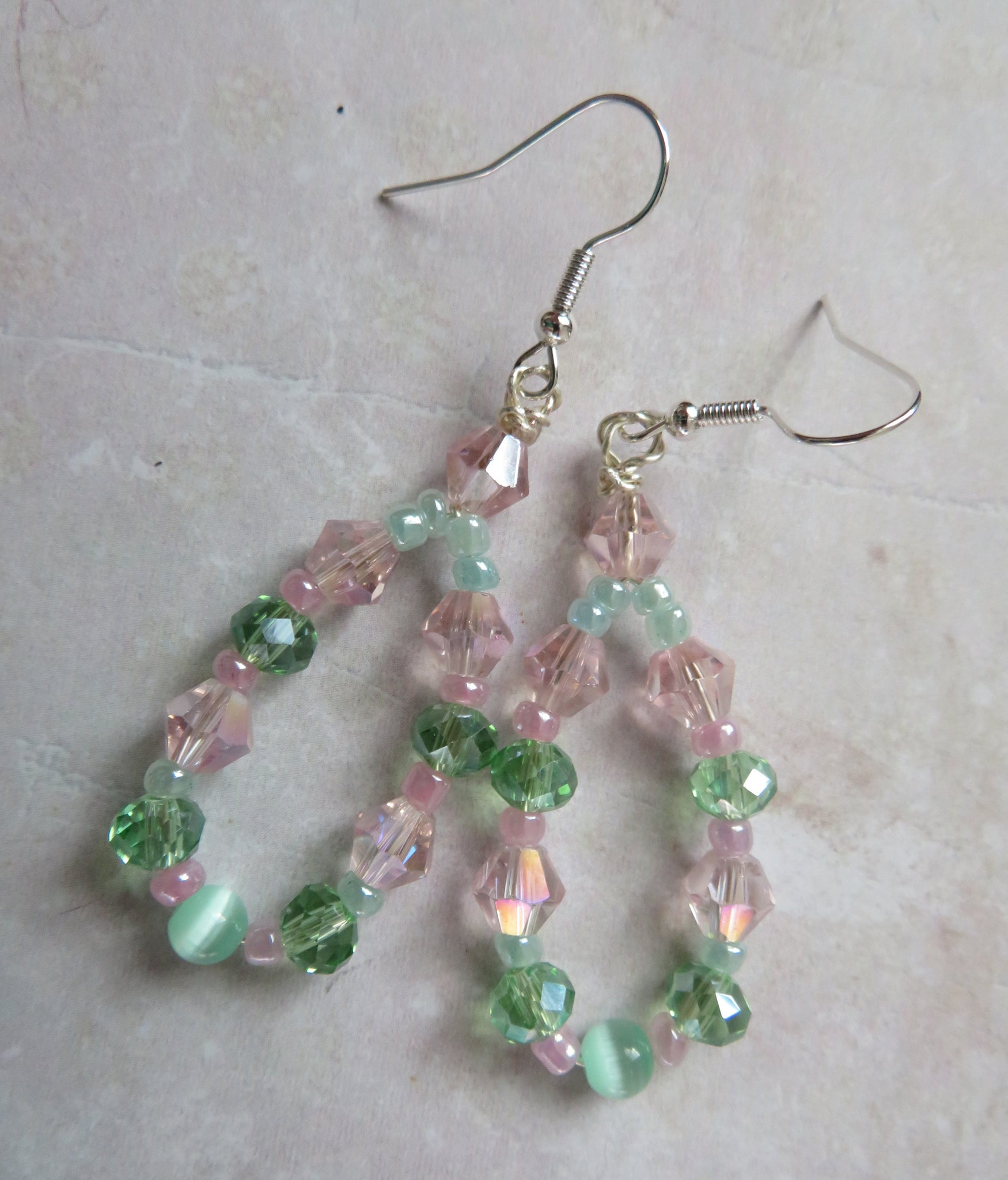 Beaded earrings with pink and green beads on a light background