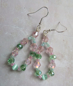 Beaded earrings with pink and green beads on a light background