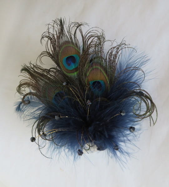 Peacock feather hair clip on a white background