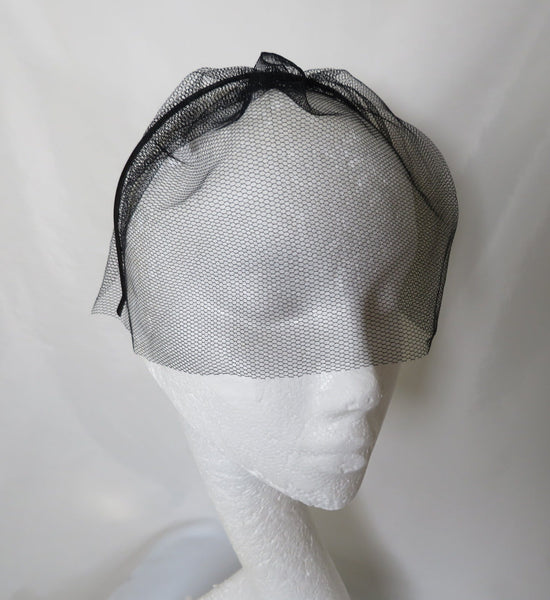 sheer black veil on a headband in tulle dress net comes to the end of the nose and covers eyes and forehead on a black metal headband easy to wear just pop on head 