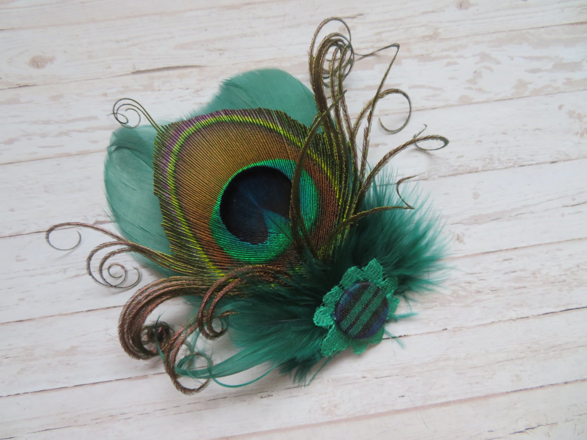 bottle green feather hair clip with a large peacock feather and a black watch green tartan button