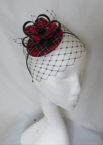 Red and black plaid flower with a black veil on a mannequin head against a white background