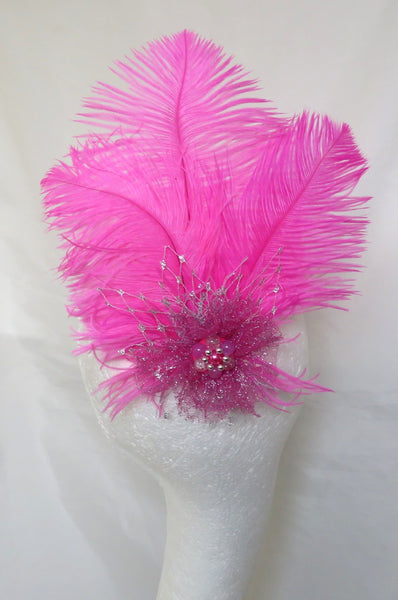 Pink feathered hair accessory on a mannequin head against a white background