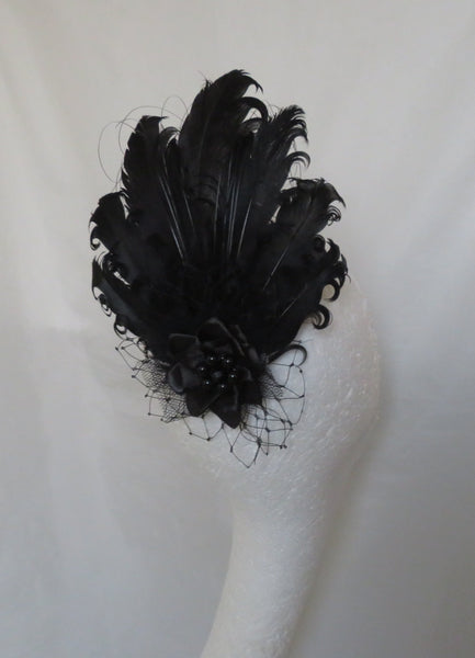 Black feathered hairpiece on a white background