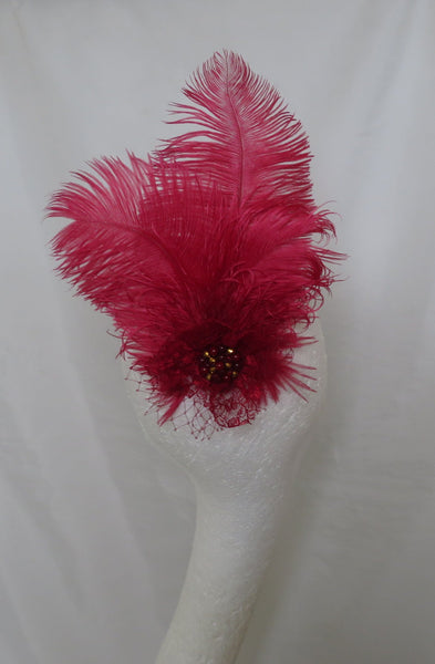 White shower curtain with a red feather decoration in a bathroom setting