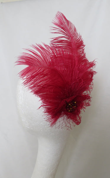 Red feathered brooch on a white garment