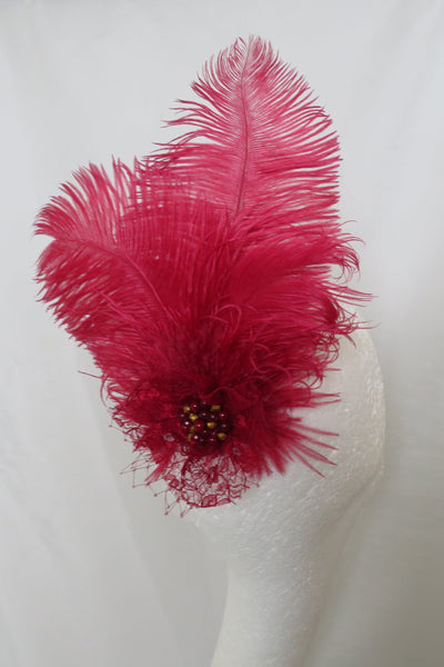 Red feathered brooch on a white garment