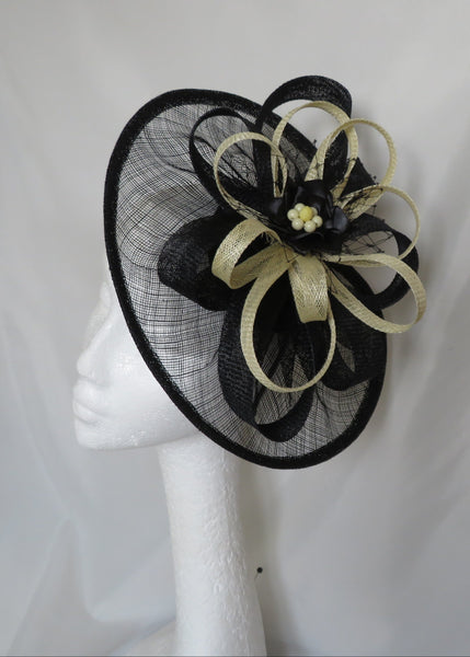 Black and gold decorative headpiece on a mannequin head against a white background