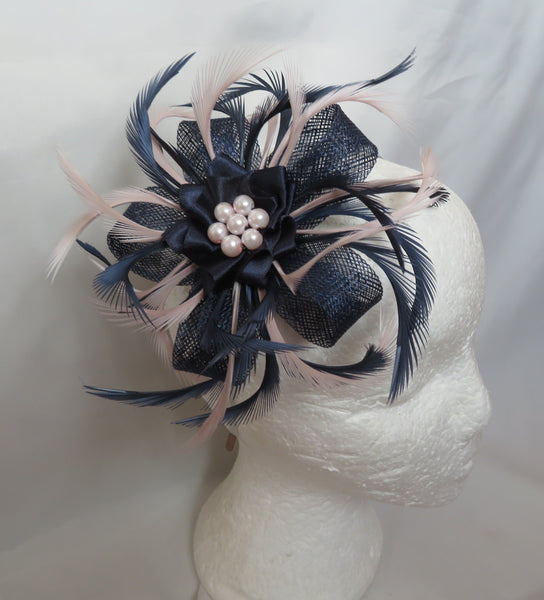 Navy and pink feathered hair accessory on a mannequin head against a white background