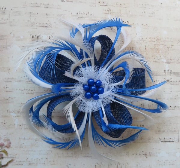 Blue and white feathered flower accessory on a textured surface