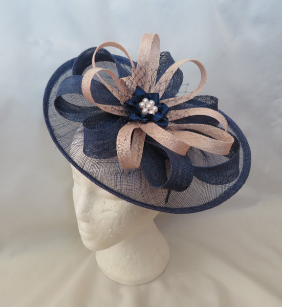 Navy blue and beige decorative headpiece on a mannequin head against a white background