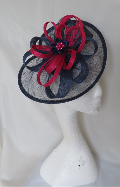 navy and cerise pink decorative headpiece on a mannequin head against a white background