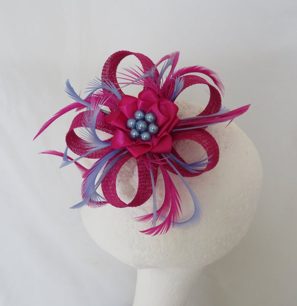 Pink feathered hair accessory on a mannequin head against a white background