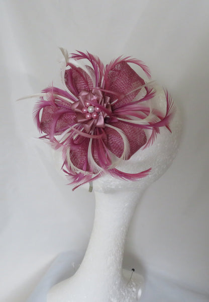 Pink feathered hair accessory on a mannequin head against a white background