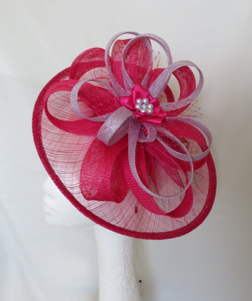 Pink decorative bow with a central flower on a white background