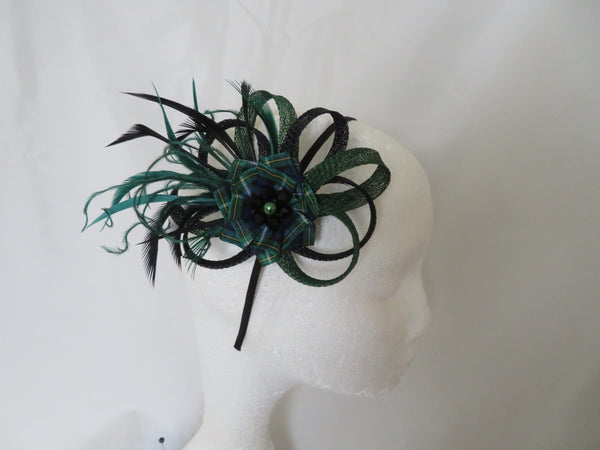 Green feathered tartan headpiece on a mannequin head against a white background