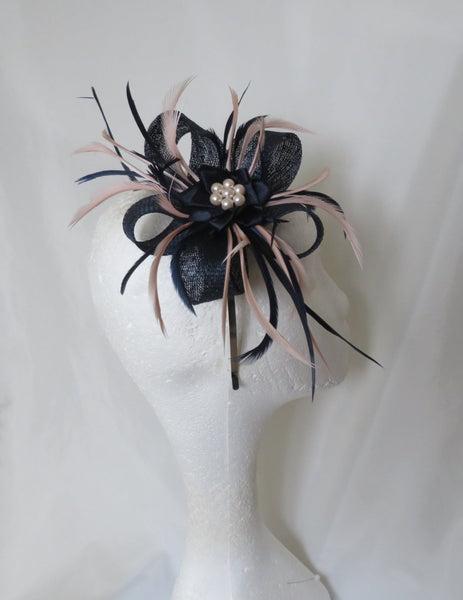 navy blue and pale blush antique pink fascinator with long feathers sticking out in a bow shape with a pearl flower in the middle, on a headband or clip for a wedding